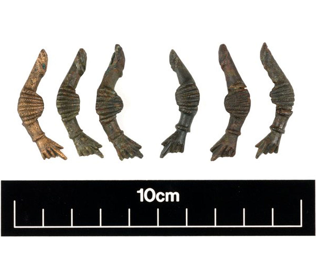 Six small, curved amulets with a fist at one end and a penis at the other Six small, curved amulets with a fist at one end and a penis at the other
