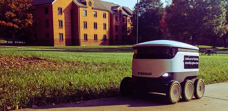 Photo of a Starship delivery drone on a sidewalk.