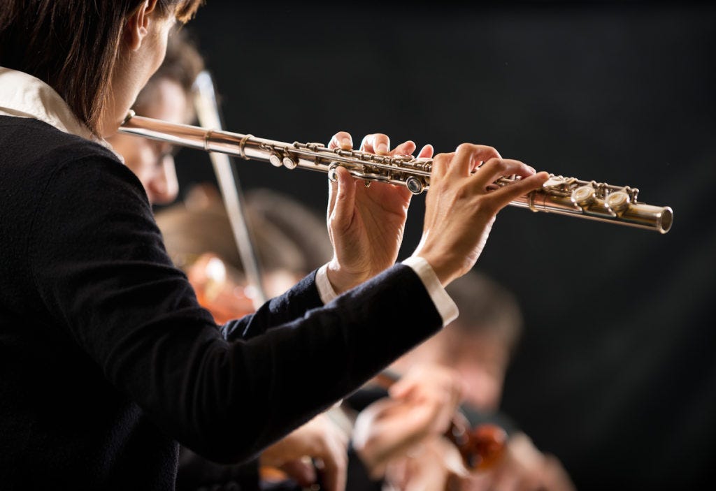 Female flutist with orchestra on stage