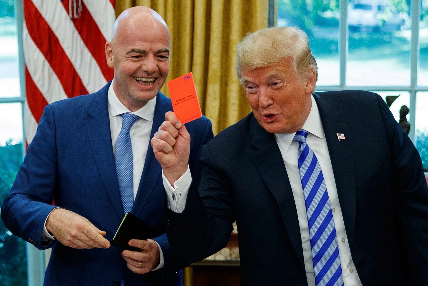 Donald Trump holds up a red card during a meeting with Gianni Infantino, the FIFA president, in the Oval Office of the White House in Washington, DC, on 28 August 2018. Donald Trump holds up a red card during a meeting with Gianni Infantino, the FIFA president, in the Oval Office of the White House in Washington, DC, on 28 August 2018.