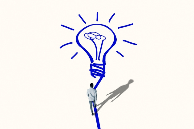 Young man walking towards bright blue bulb