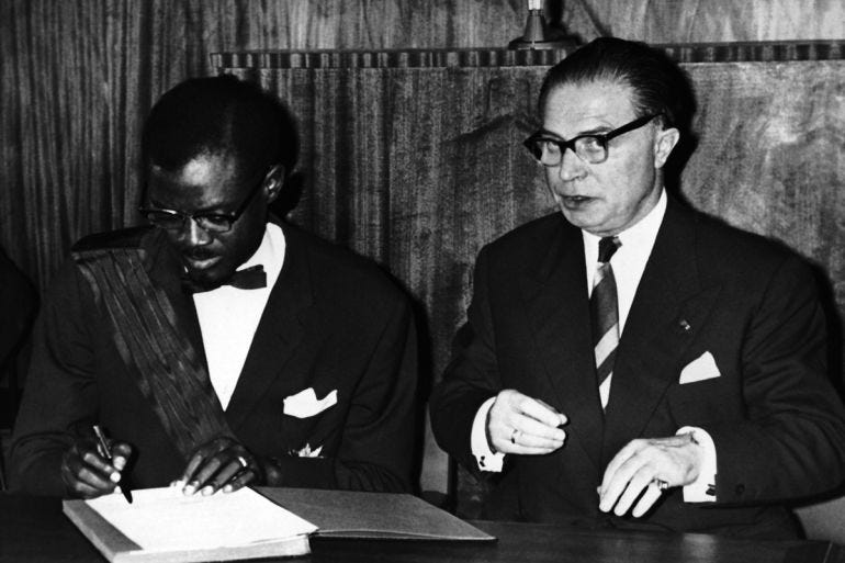 Patrice Lumumba, the Prime Minister of the Congo, signs the act of independence of the Congo in Leopoldville, Congo on June 30, 1960. At right is Gaston Eyskens, Prime Minister of Belgium, who signed