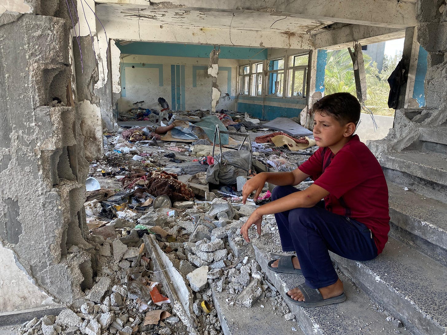 Boy sitting in the rubble of a destroyed UNRWA school in Nuseirat, Middle Areas. © 2024 UNRWA Photo Boy sitting in the rubble of a destroyed UNRWA school in Nuseirat, Middle Areas. © 2024 UNRWA Photo