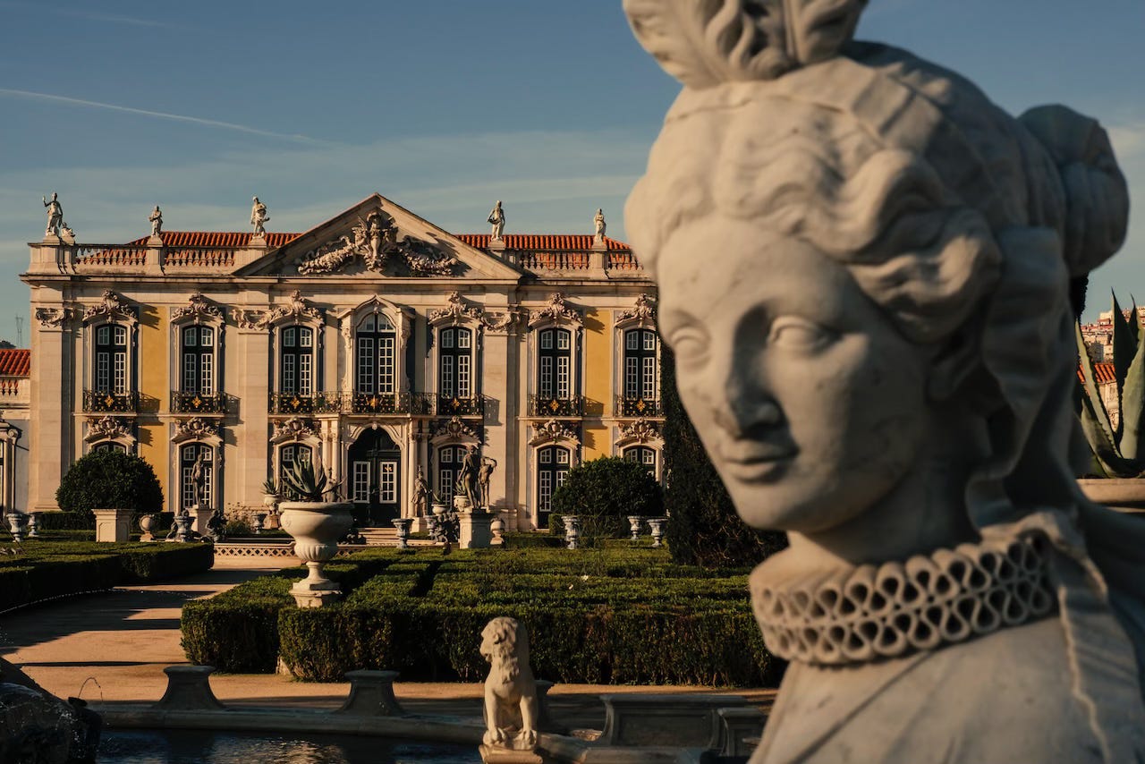 View of the gardens and yellow façade of the Palácio Nacional de Queluz