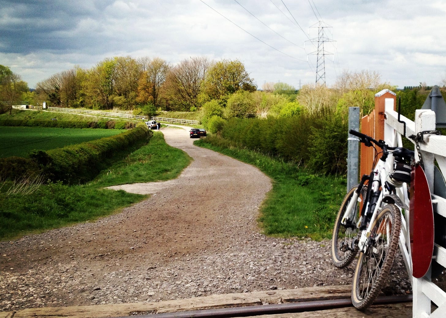 A bike leans on a gate at a level crossing