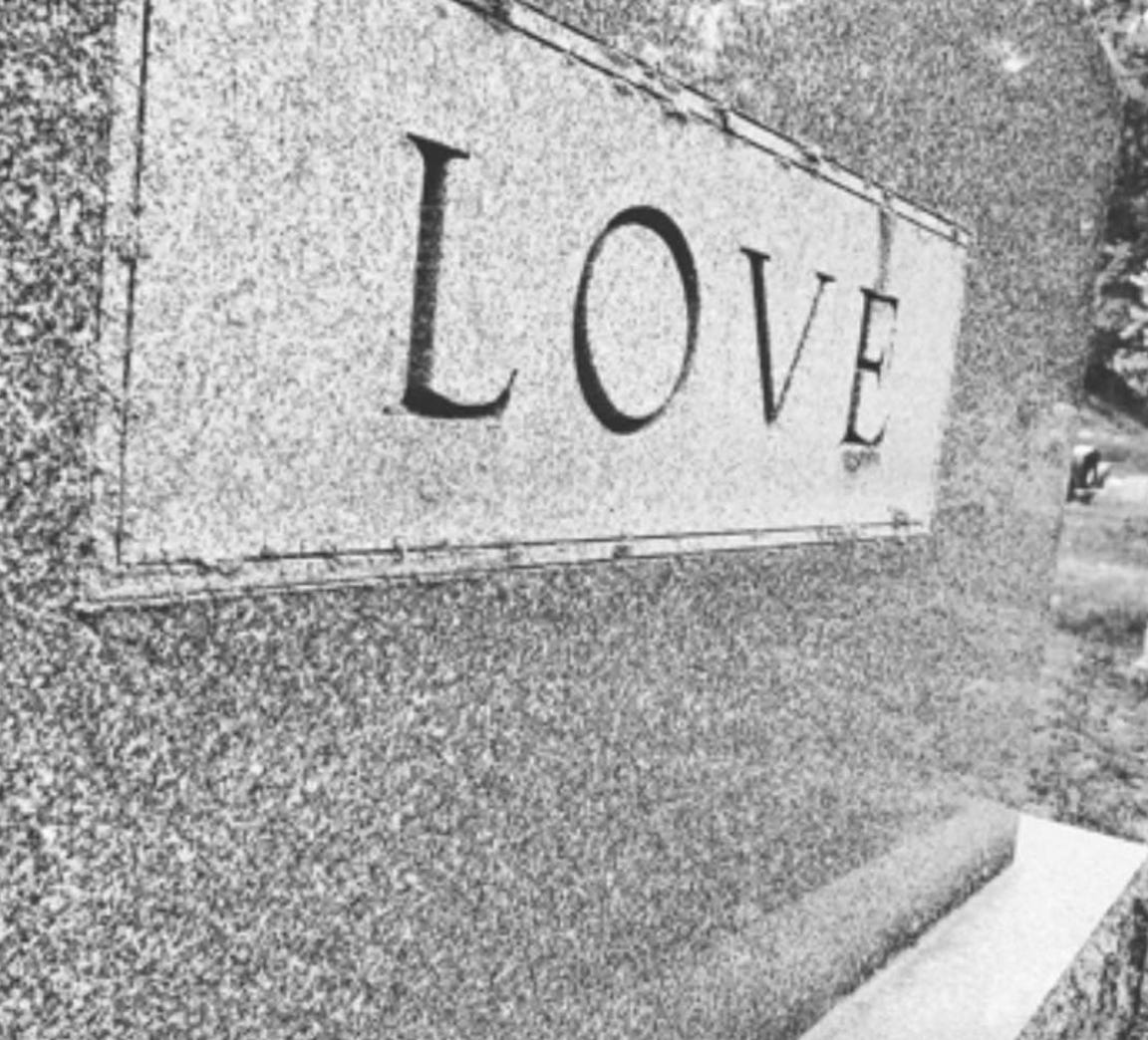 a black and white photo of a tombstone that says "Love"