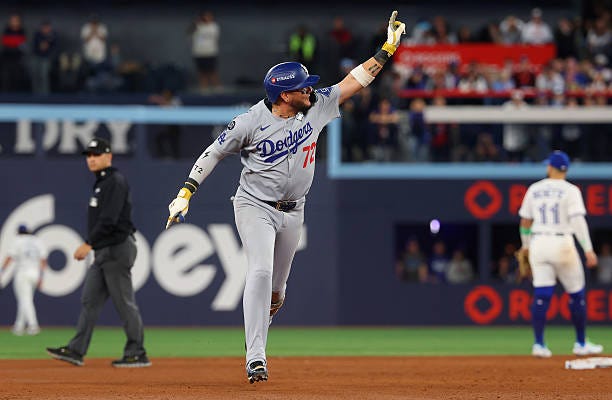 Miguel Rojas of the Los Angeles Dodgers celebrates as he rounds the bases after hitting a game-tying home run during the ninth inning against the...