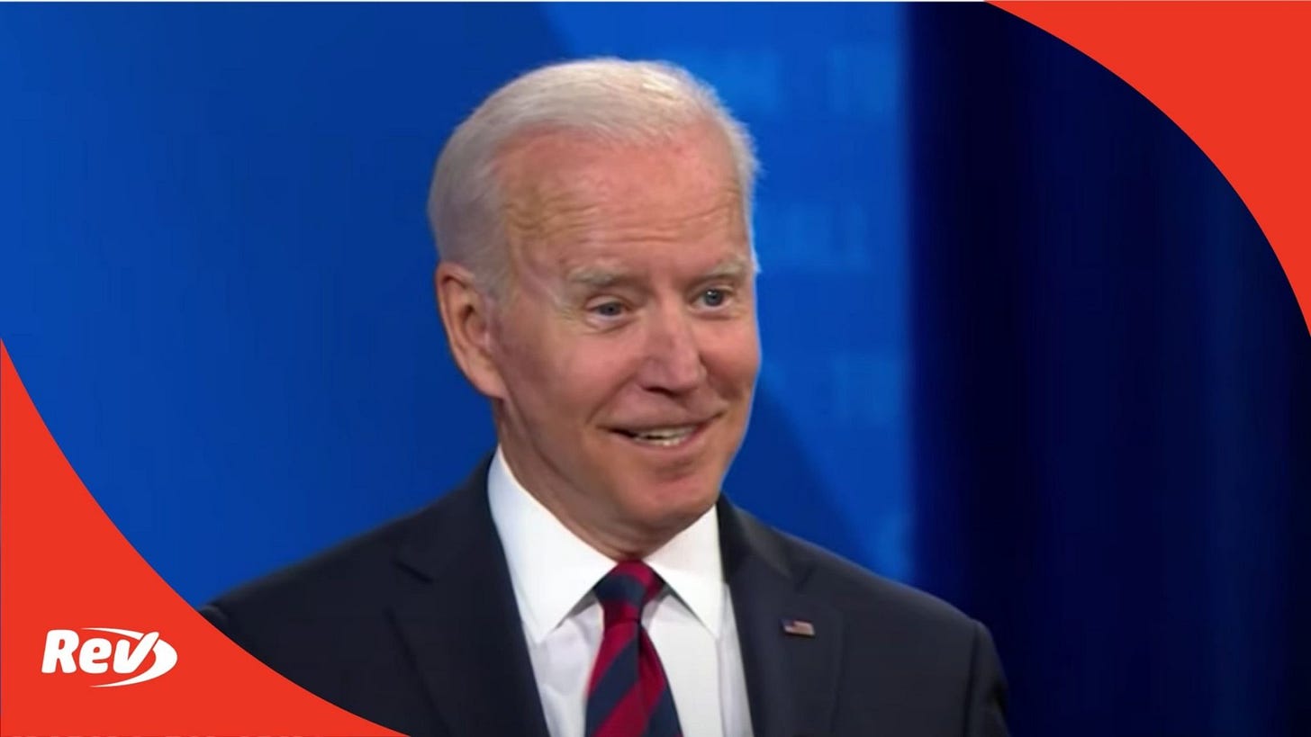 President Joe Biden smiling in suit and striped tie on blue CNN town hall set with Rev logo