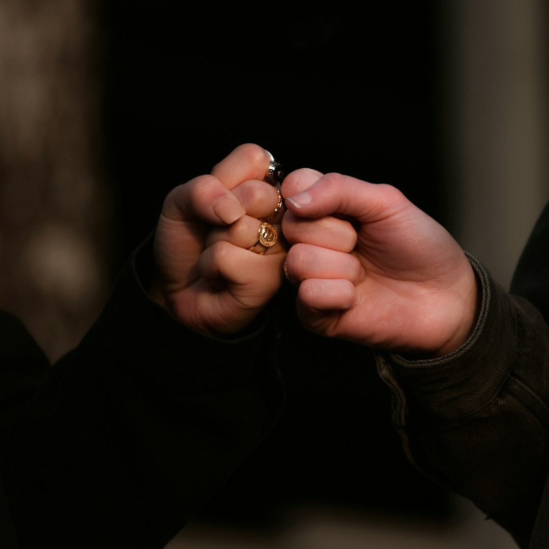 person holding gold ring in dark room person holding gold ring in dark room