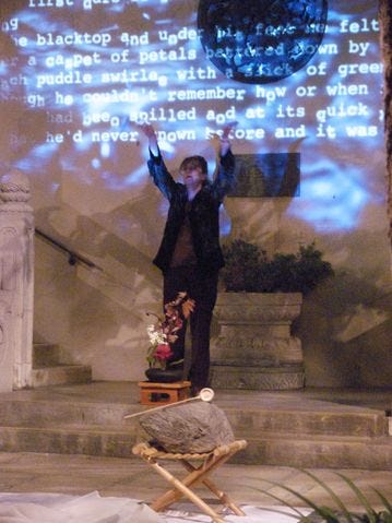 A person standing on a stage with his hands up

Description automatically generated