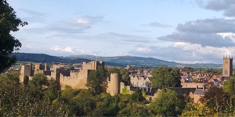 Landscape view of Ludlow with Castle and Church Spire and hills in background