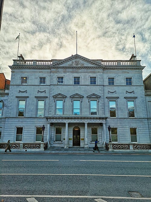 A Georgian white building with three floors.