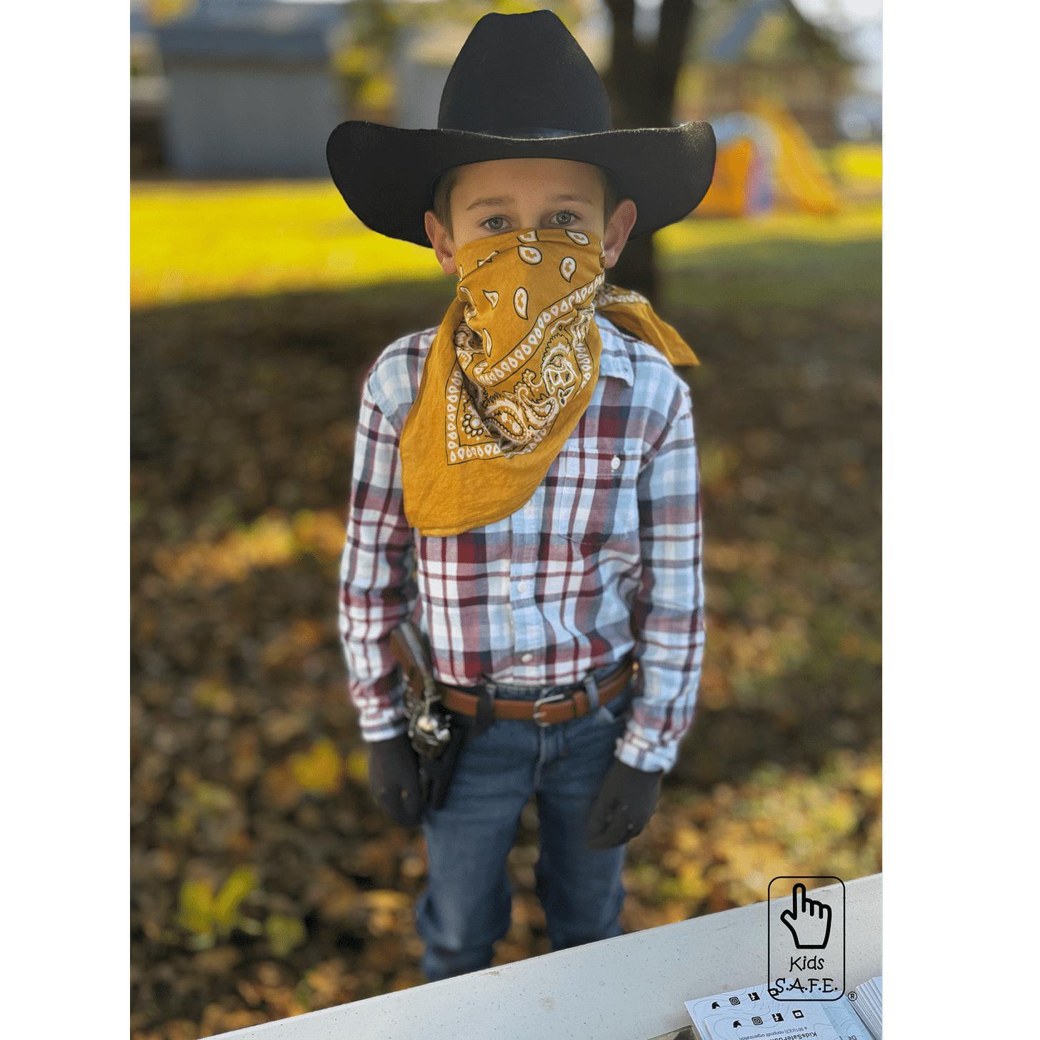 Child in cowboy costume outdoors.