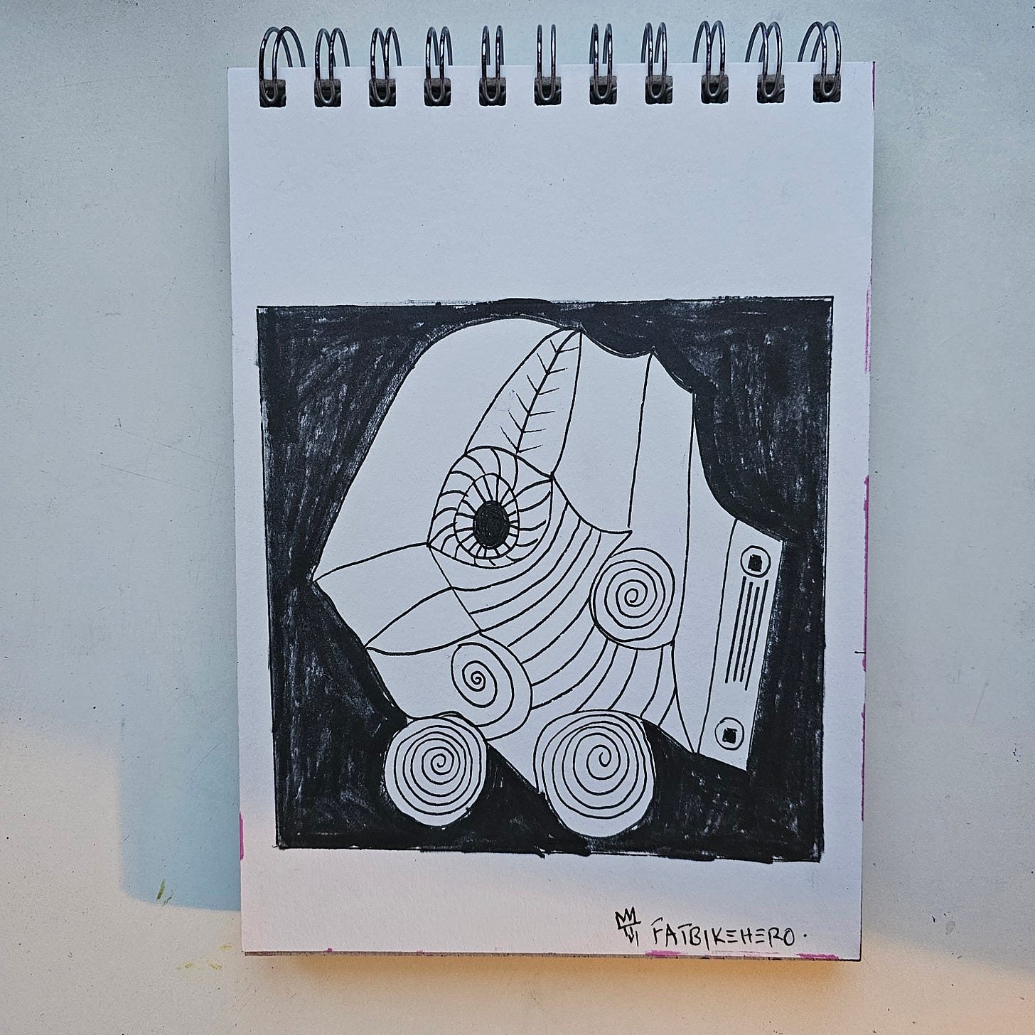 Alt Text: A black and white ink drawing by FatbikeHero titled Birdmobile. The image features a stylized, abstract bird head shaped like a vehicle or helmet, resting on two wheels with spiral patterns. The background is filled in with black ink, making the white bird figure pop.