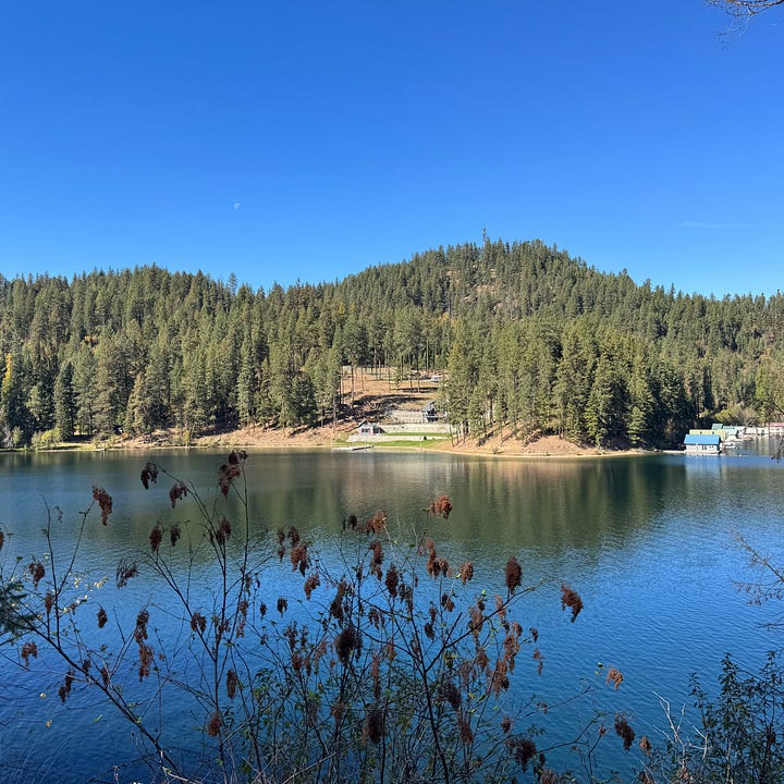 State line sign in Idaho and pictures of lake Coeur D'Alene with water and trees