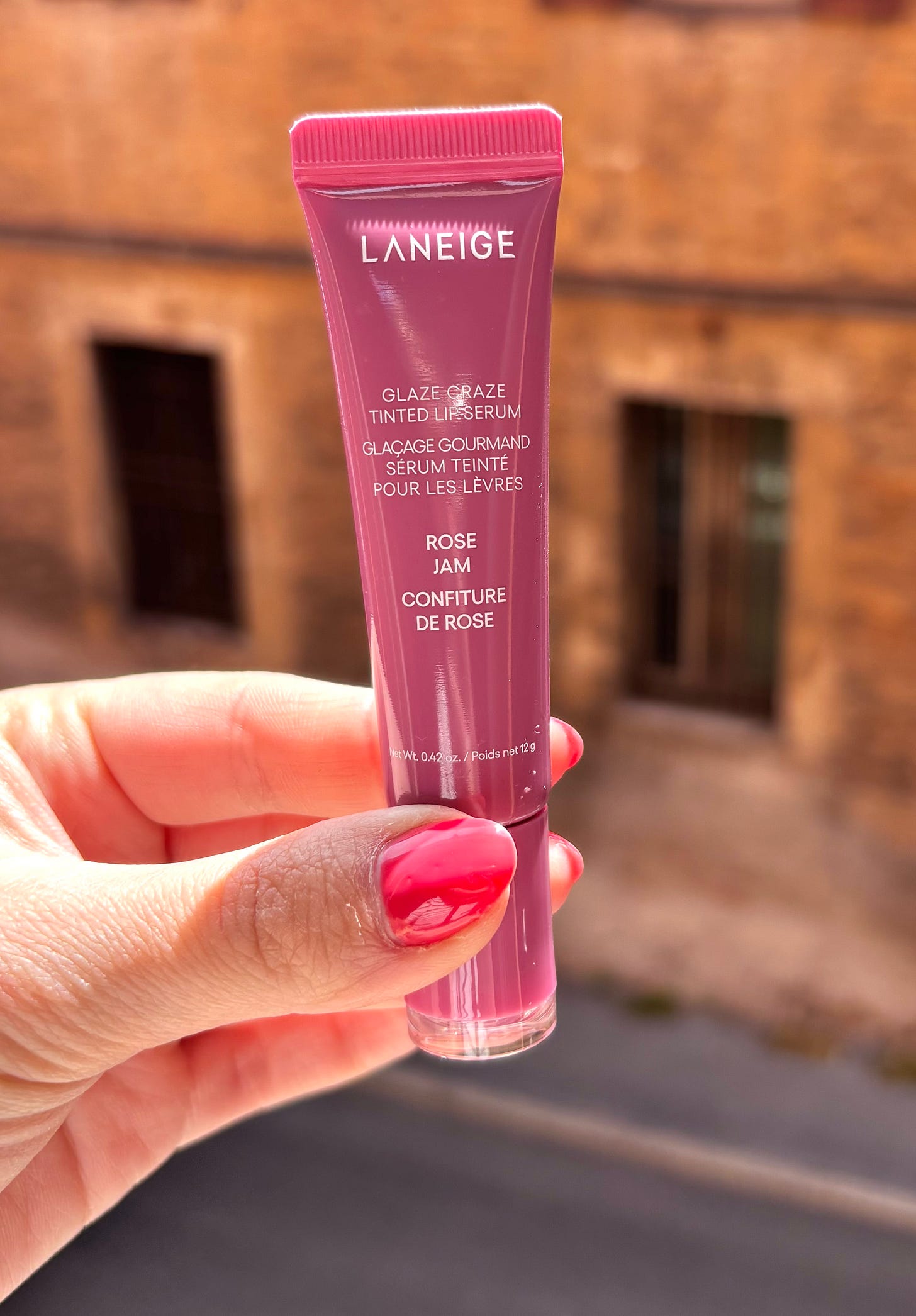 Laneige Glaze Craze Tinted Lip Serum in the shade Rose Jam showing the soft, circular doughnut-shaped applicator.