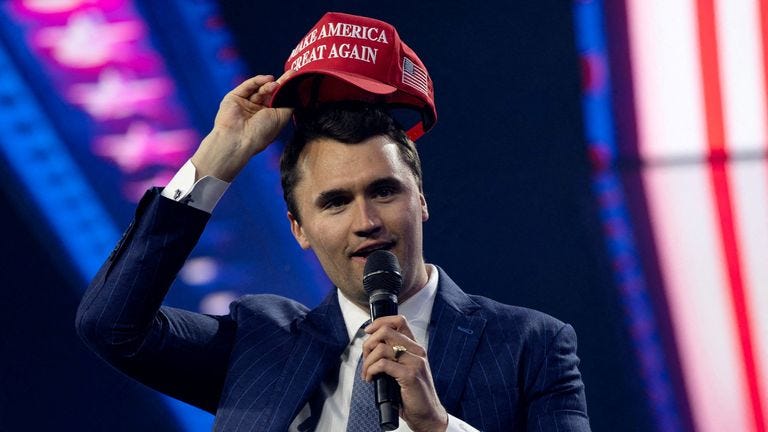 Charlie Kirk putting on a MAGA hat at a conservative conference in 2024. Pic: Reuters