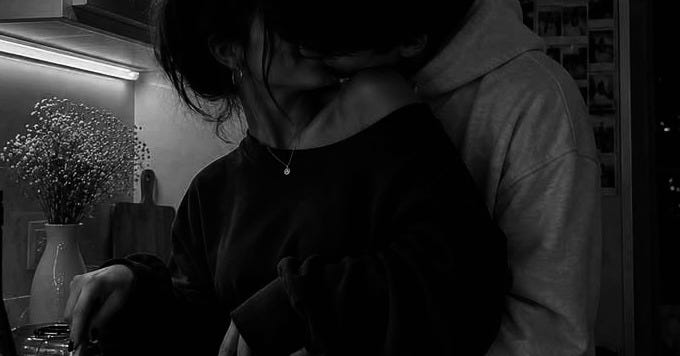 pareja besándose en la cocina mientras ella prepara algo para cenar pareja besándose en la cocina mientras ella prepara algo para cenar