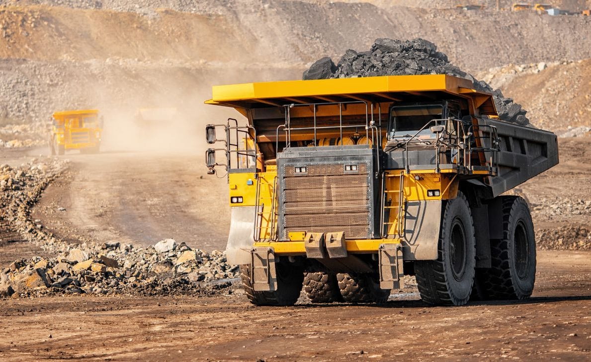Giant mining truck loaded with ore driving in a pit mine.
