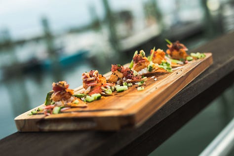 “Chefs from Aramark Collegiate Hospitality showcasing coastal-inspired dishes at the NC Seafood Festival 2025 — including seafood risotto, crab gumbo, and fried shrimp tacos — during live cooking demos and tastings with festival guests.”