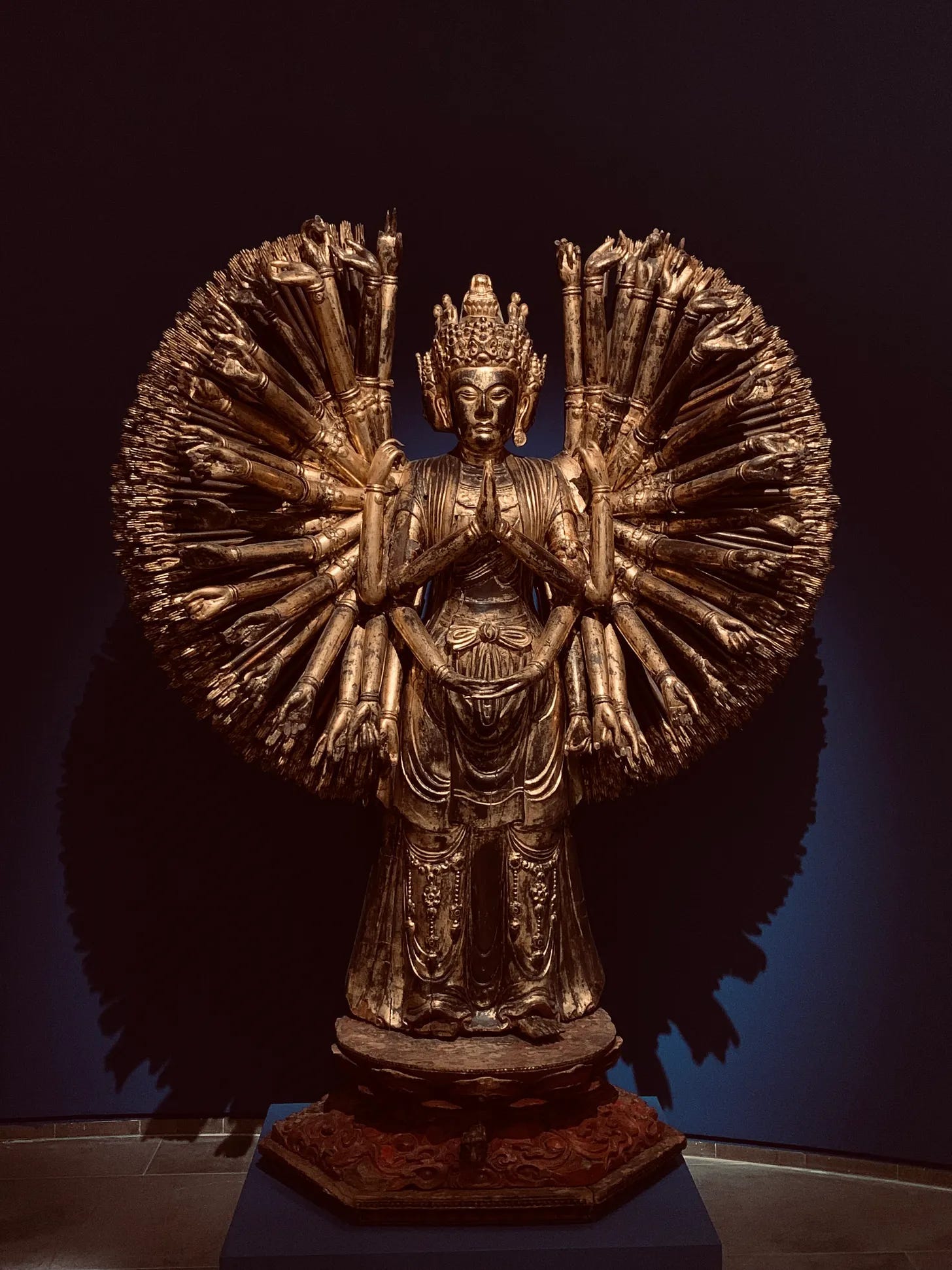 A statue of a person with many hands

Description automatically generated