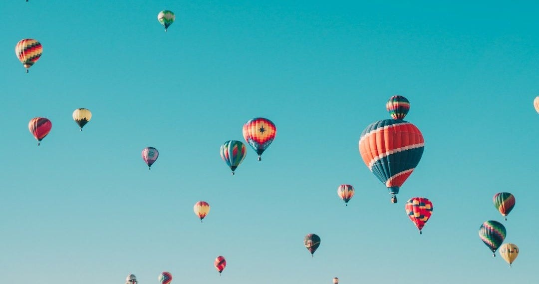 assorted hot air balloons flying at high altitude during daytime