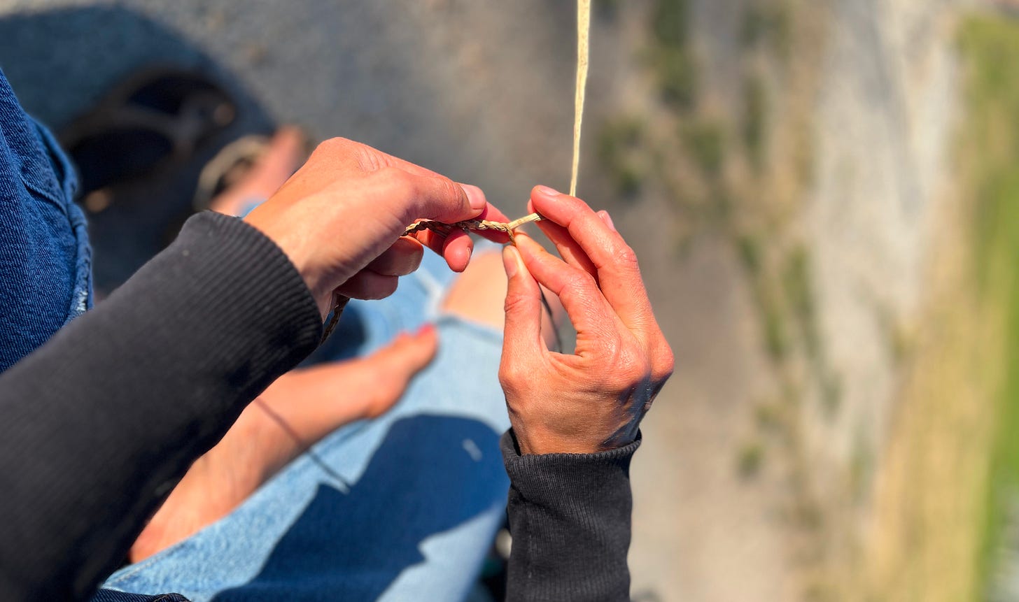 rayanns hands in bright sun cording cattail together