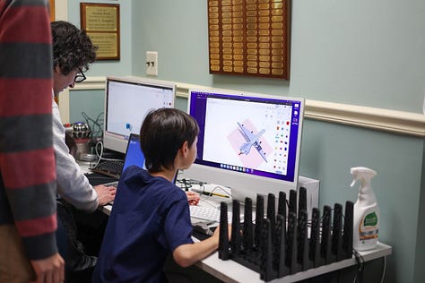 Nine square images from STEM Day, including two students 3d designing, a student sharing his Mars Rover Scratch game, a little kid building with MOLA kit, 3D-Click activities, Tiny robots!, Exploring resources