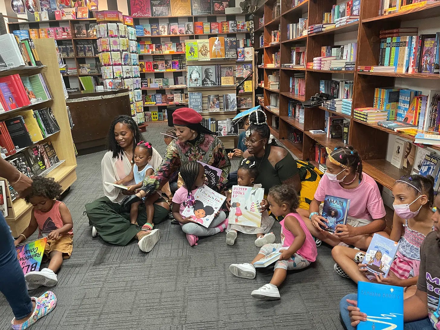 Guests holding books at a Malik Books community event in Los Angeles Guests holding books at a Malik Books community event in Los Angeles