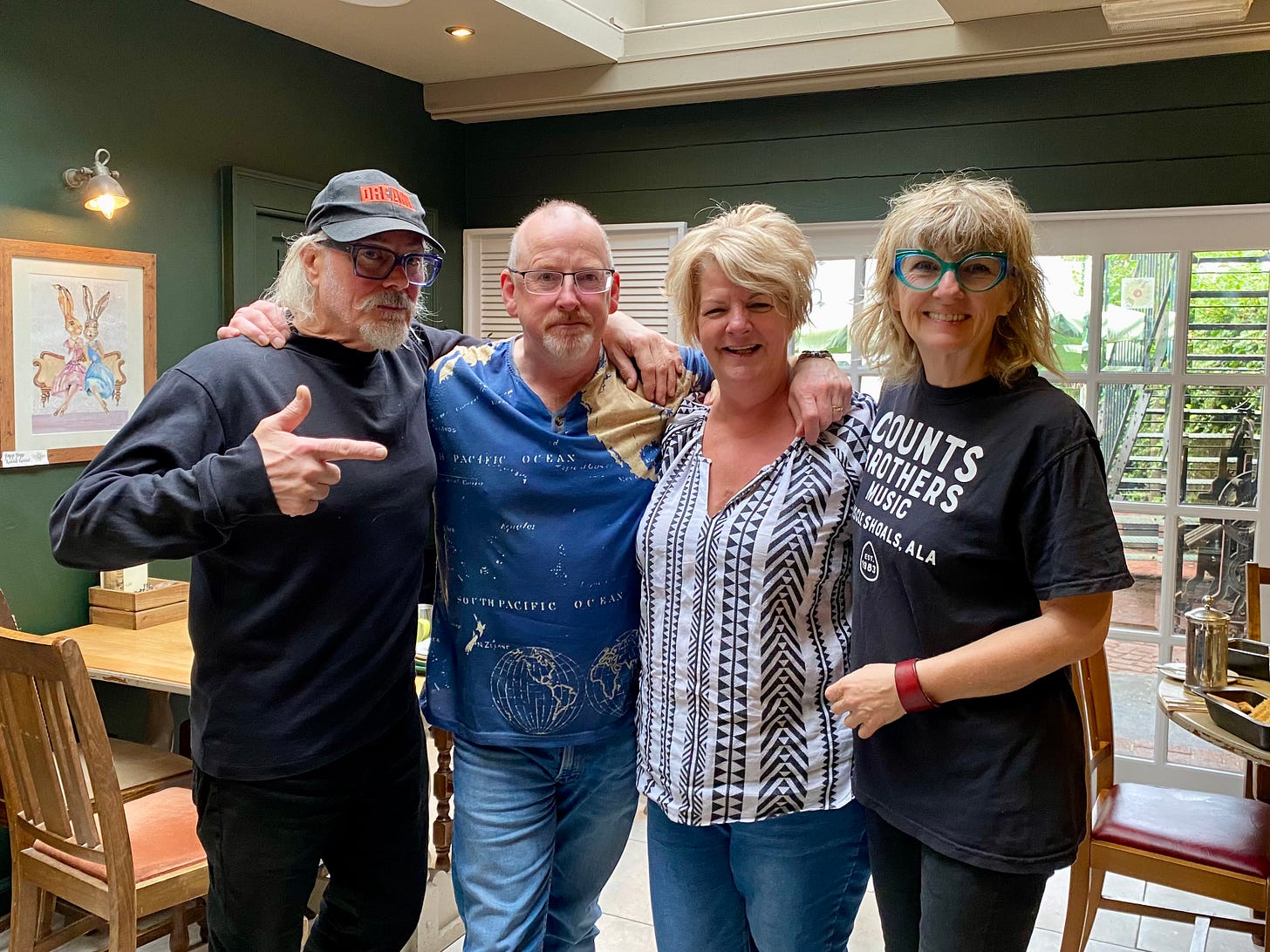 Two men and two women smiling inside a restaurant
