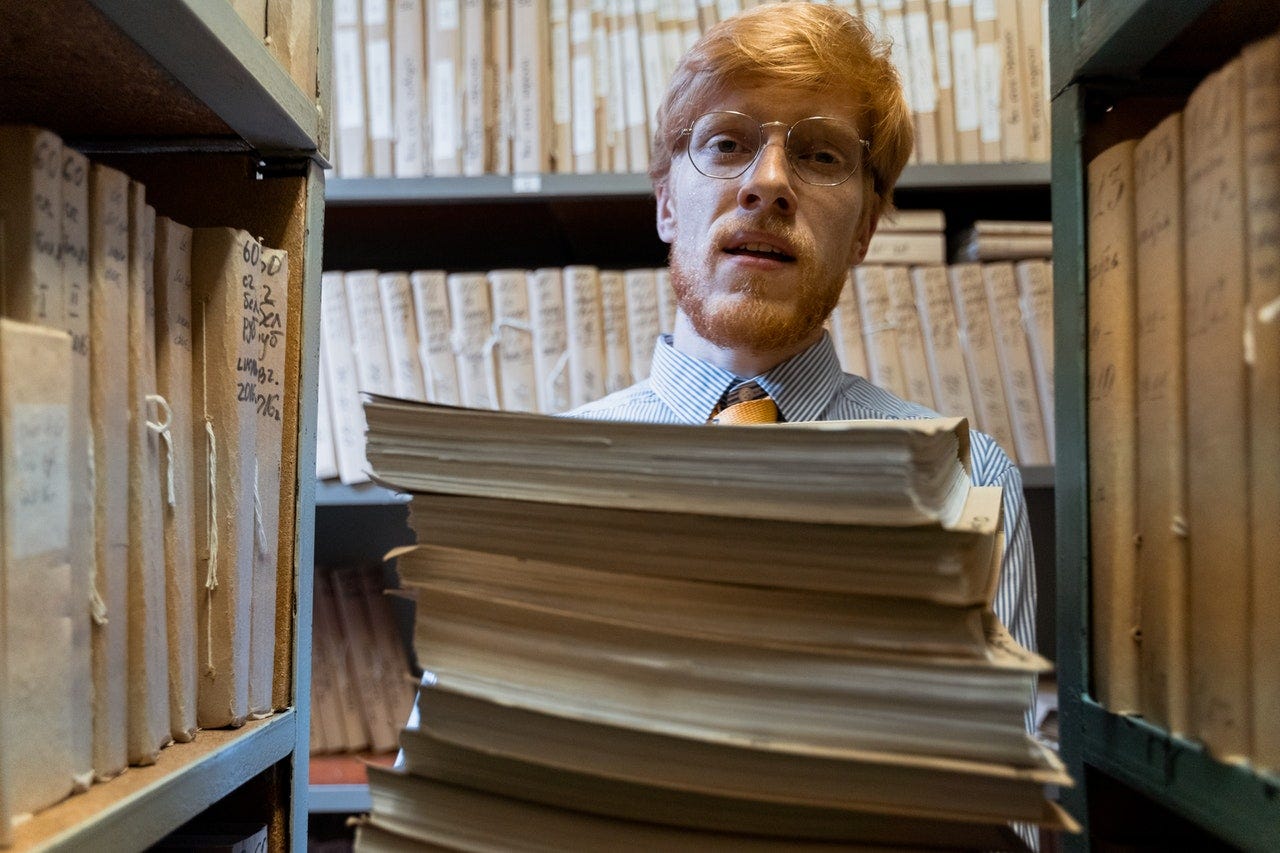 Photo by MART PRODUCTION: https://www.pexels.com/photo/a-man-carrying-a-pile-of-documents-8872512/