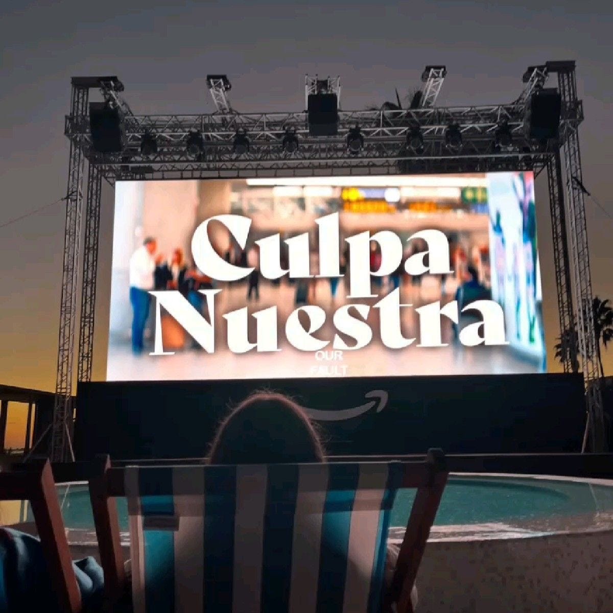Imagen de una chica tumbada en una hamaca frente a una pantalla de cine viendo Culpa Nuestra Imagen de una chica tumbada en una hamaca frente a una pantalla de cine viendo Culpa Nuestra