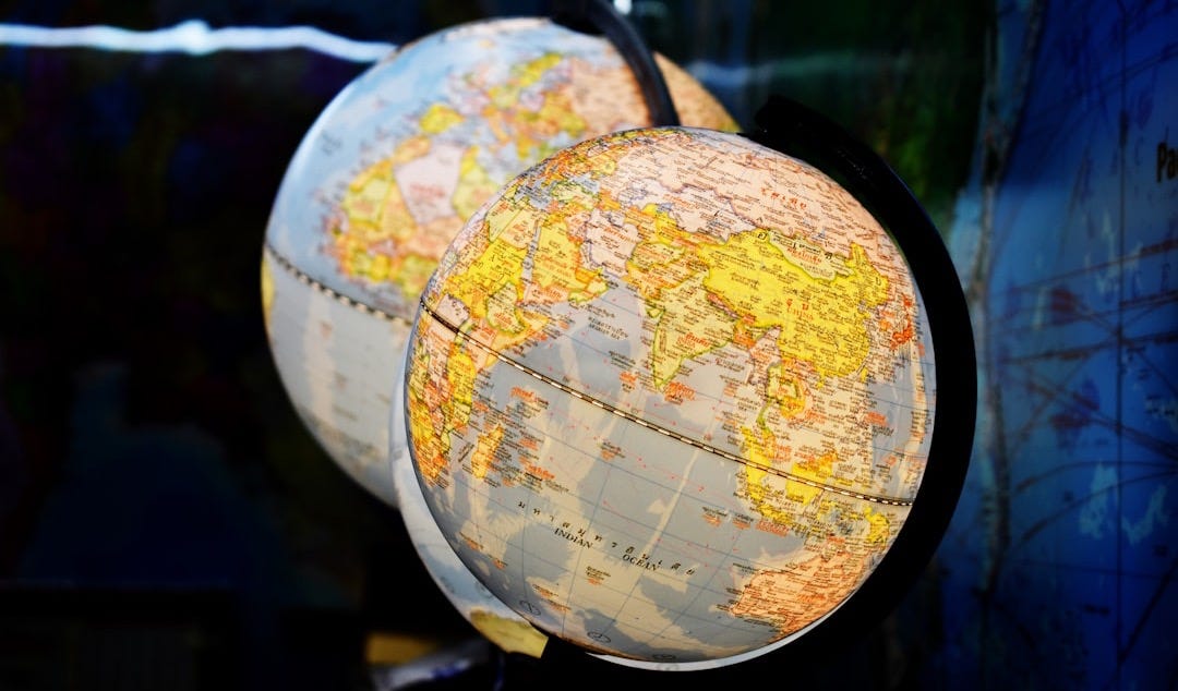 shallow focus photography of two desk globe shallow focus photography of two desk globe