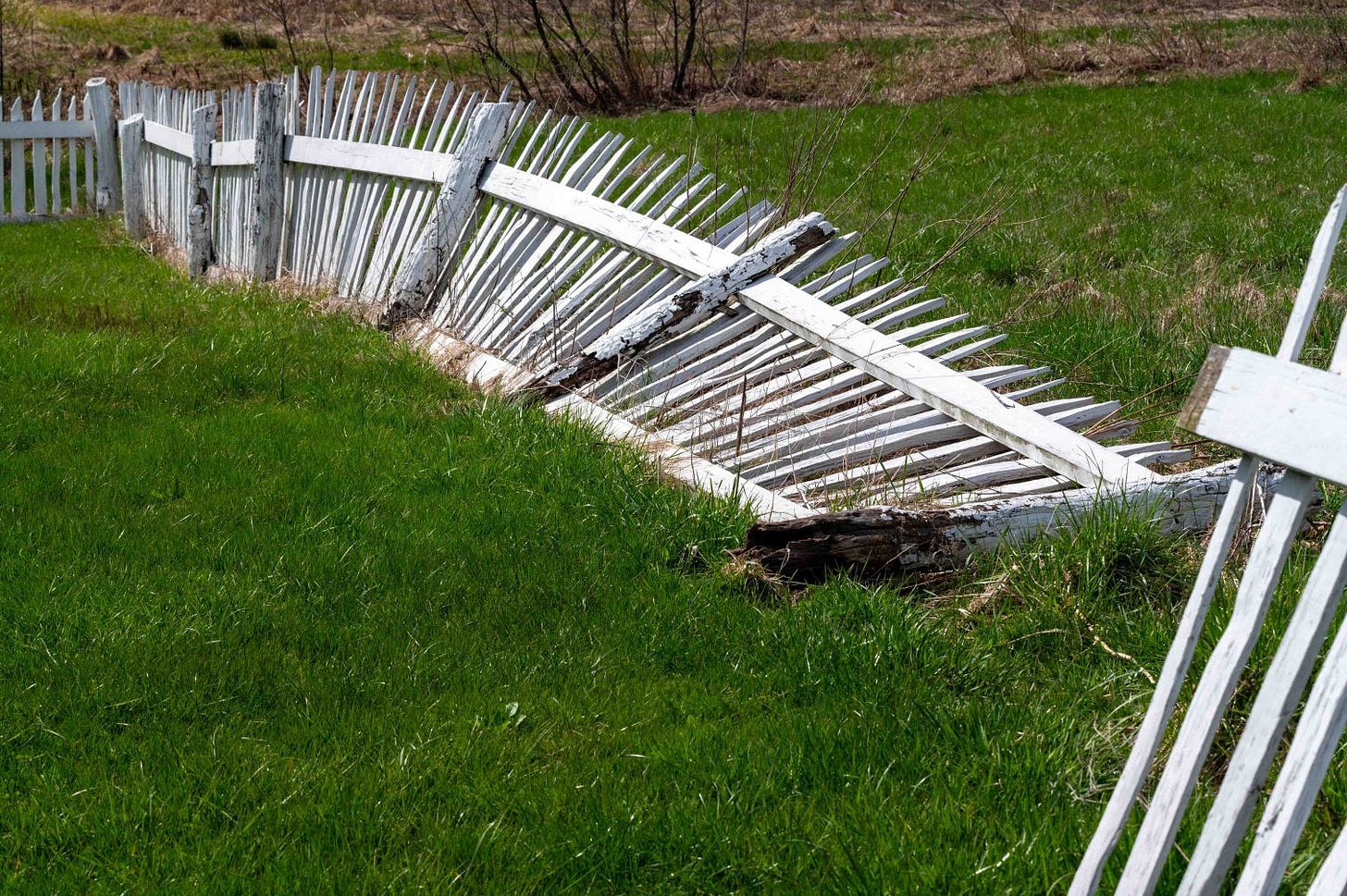 A broken white picket fence