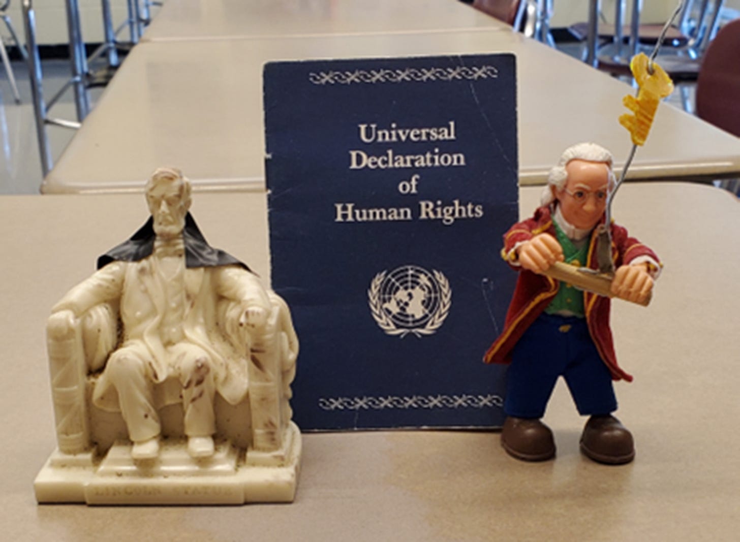 A damaged Lincoln and Ben Franklin with his kite frame the Universal Declaration of Human Rights