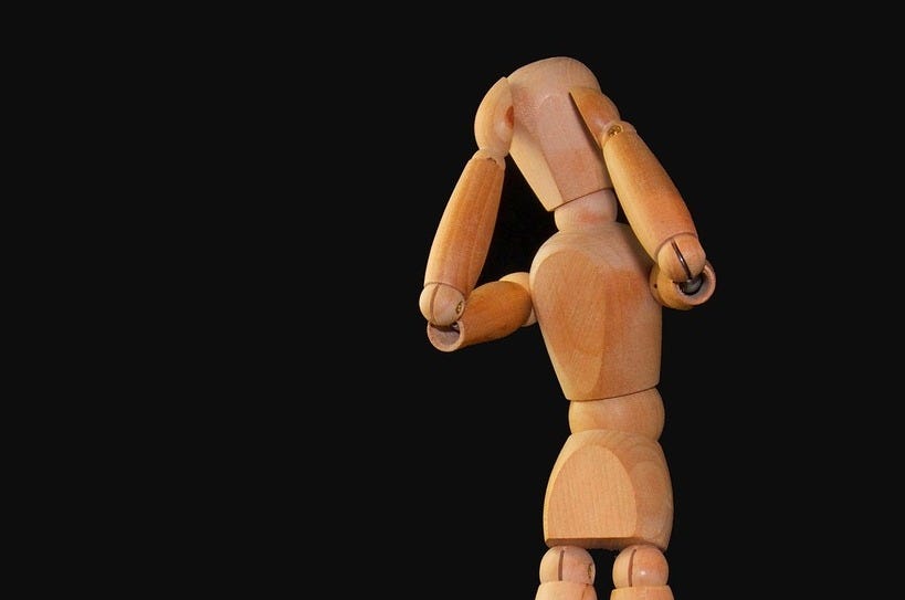 A wooden mannequin standing on a black background. Figure man stand.
