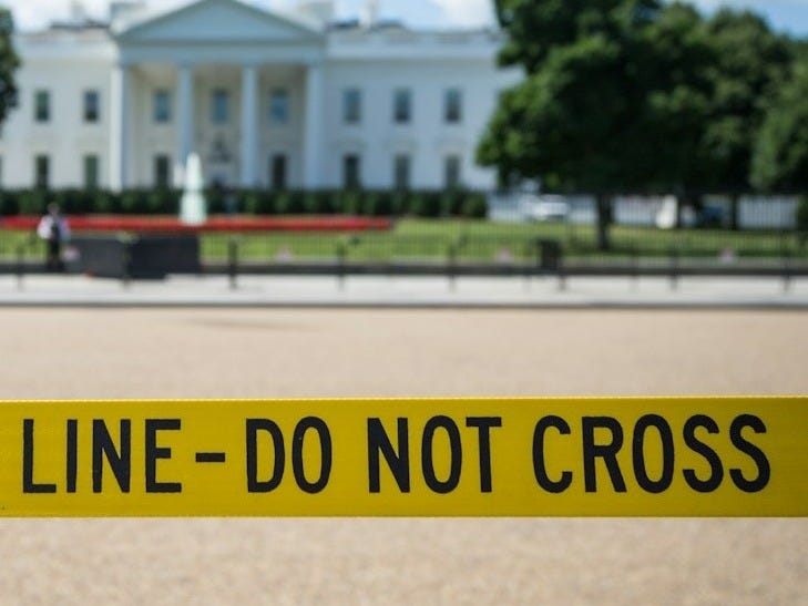 Police line-do not cross stanchion near trees under blue sky at daytime