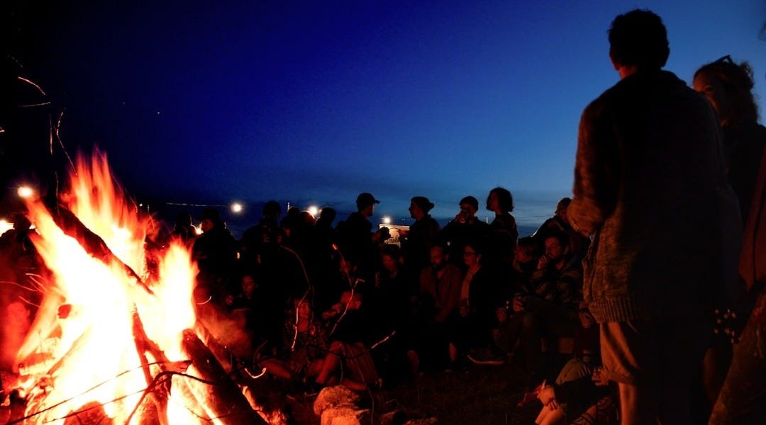 people gather near bonfire during night