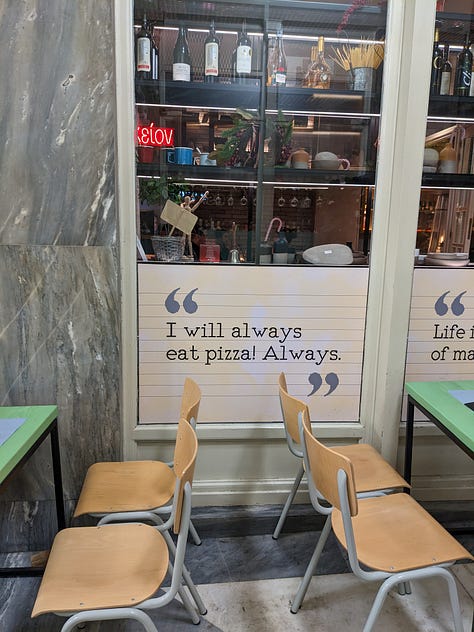 Baklava in a to-go container, a sign describing Greek ruins, and a sign in a pizza shop saying "I will always eat pizza. Always"