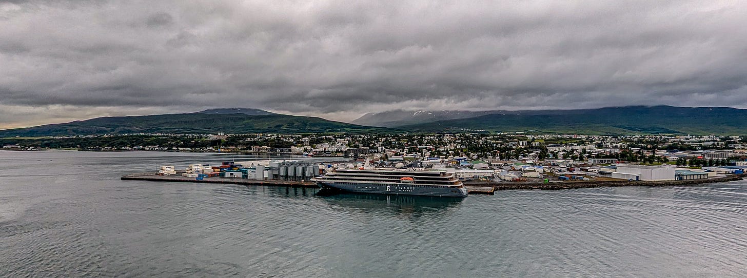A wide shot of the town, a cruise ship in the foreground. 