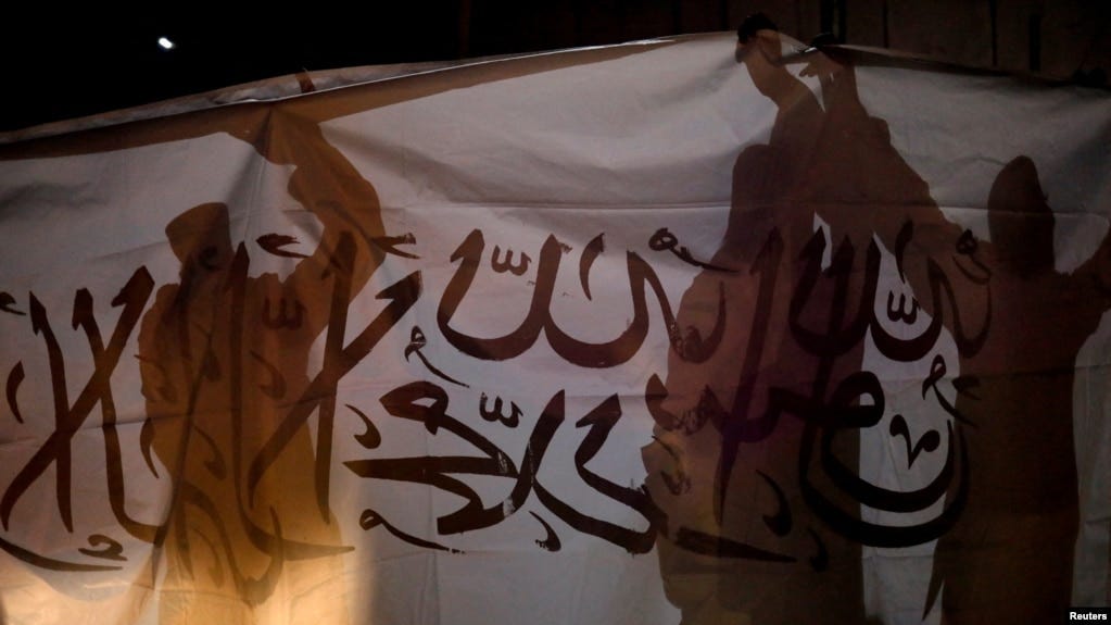 FILE - Taliban supporters hold an Islamic Emirate of Afghanistan flag during a rally in Kabul, Afghanistan, Aug. 30, 2022.