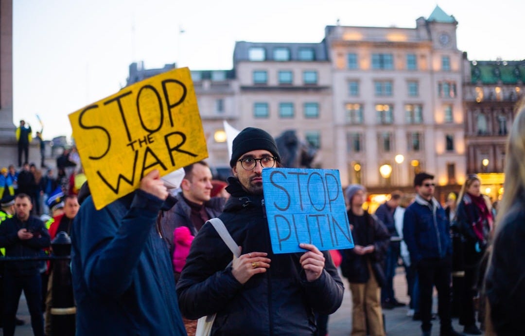 a man holding a sign that says stop the war