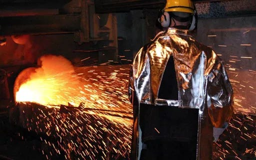 Photo of man working with molten steel.