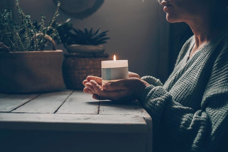 Christian woman kneeling and praying near candles He seeks guidance in his religious faith and spirituality Spirit of Christianity and faith in the goodness of God