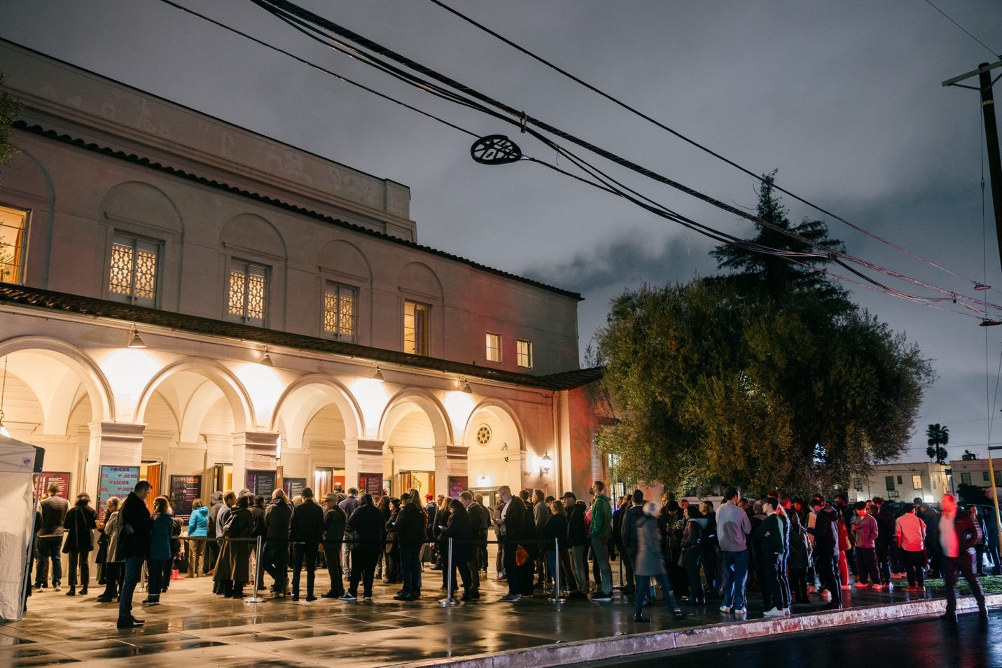 A group of people standing outside a building

Description automatically generated