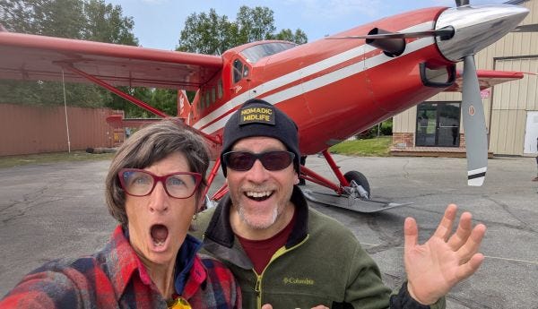 Andy and I looking excited and surprised on the ground, in front of the red airplane