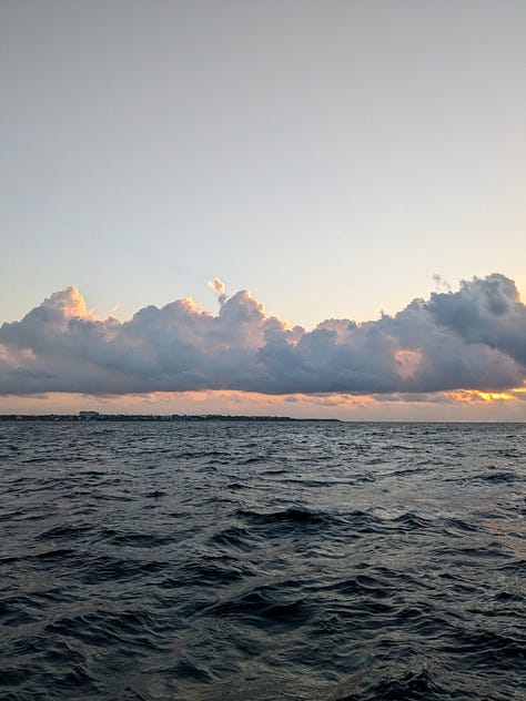 Me on my penultimate morning watch, Isla Mujeres on the horizon, and our boat tied up for entry proceedings.