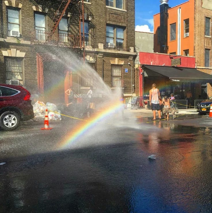This may contain: a fire hydrant spewing water into the street