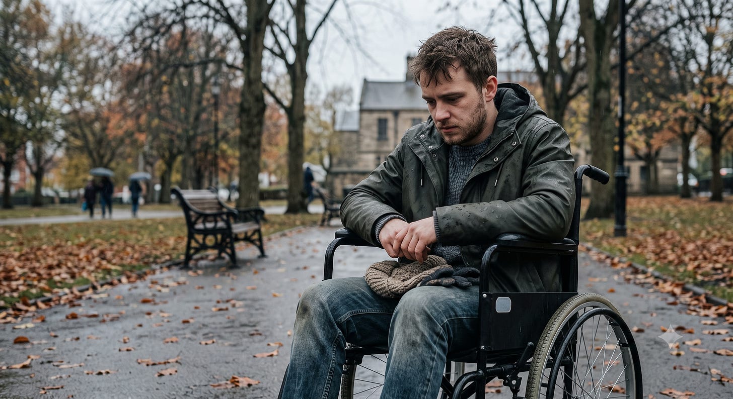 A young man in a wheelchair sits alone on a wet park path in the rain, head bowed, clutching a knit hat in his lap. A young man in a wheelchair sits alone on a wet park path in the rain, head bowed, clutching a knit hat in his lap.