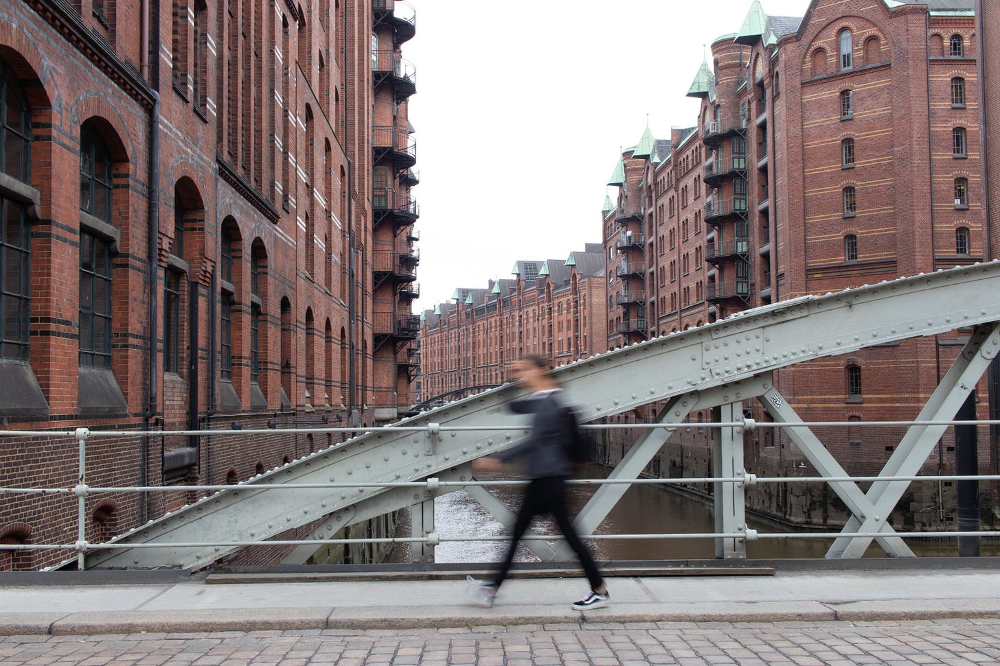 Blurred motion of a person walking on a bridge in a historic red brick warehouse district Blurred motion of a person walking on a bridge in a historic red brick warehouse district